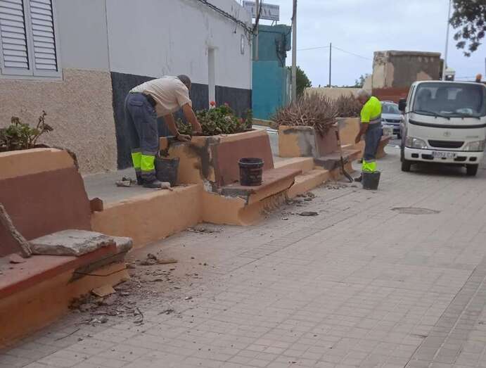 Operarios arreglando los bancos de mampostería/TA.